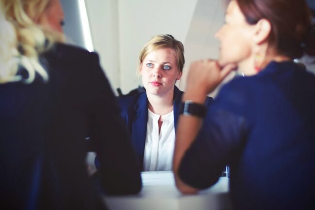 Woman in an interview with two other women conducting it